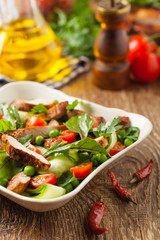 Delicious salad with grilled veal, beetroot and cucumber. Front view.