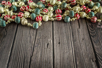 New year concept. Colorful Christmas beads on dark wooden background. Top view, flat lay composition.