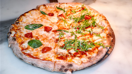 Close up of a hot, fresh out of the oven pizza on a ceramic surface