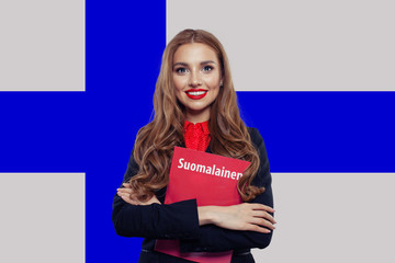 Young woman smiling and posing against the Finnish flag backgrou