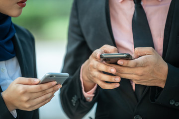 Muslim Couple on their smartphone. Texting and checking out their social media