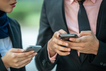 Muslim Couple on their smartphone. Texting and checking out their social media