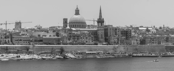 Black and white view of the basilica of our lady of mount carmel in the unesco world heritage site of valletta, capital of malta. Image viewed from the ferry crossing between valletta and sliema