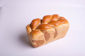 White bread baked from above in the form of a pigtail. Baking on a white background