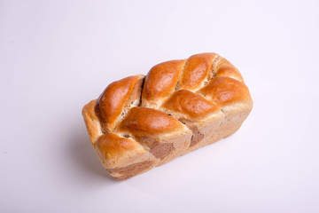 White bread baked from above in the form of a pigtail. Baking on a white background