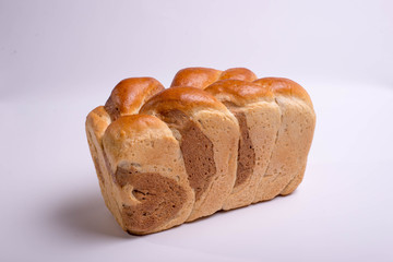 White bread baked from above in the form of a pigtail. Baking on a white background
