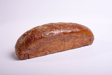 Long brown bread on a white background with crispy cumin and spices