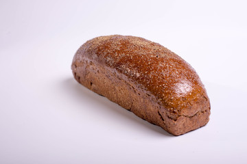Long brown bread on a white background with crispy cumin and spices