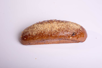 Long black bread with seeds. Baking on a white background