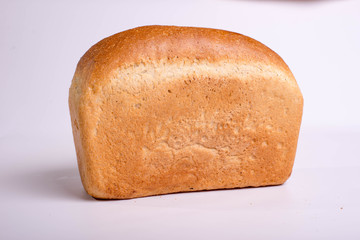 Baked loaf of bread on a white background. White square bread