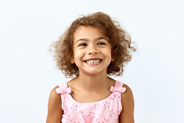 Little African American girl portrait against white background. Blissful,laughter and joy emotions