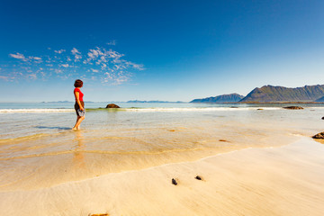 Obraz premium Woman walking on sandy beach, Lofoten Norway