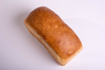 Baked loaf of bread on a white background. White square bread