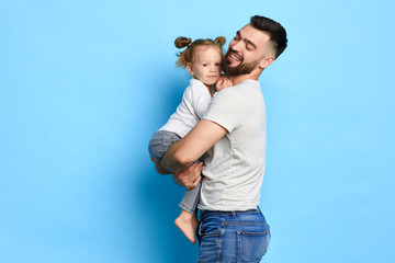 positive guy is having fun with his little baby, hugging his kid. close up photo. feeling , emotion