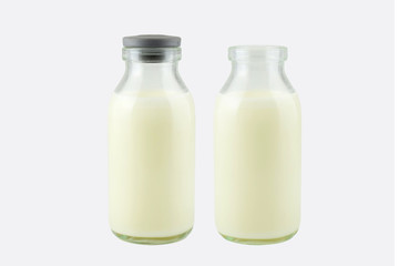  Fresh milk in a transparent bottle with and without lid, isolated on white background, frontside