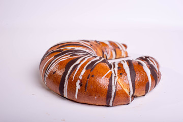 Bagel drenched in chocolate icing. Dessert pastries on a white background