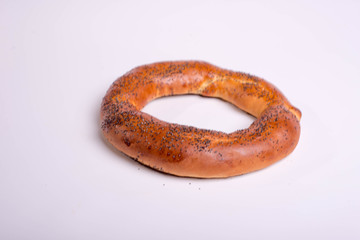Bagel with poppy seeds. Round dessert pastry on a white background