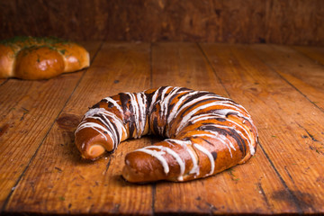 Delicious dessert on a wooden table. Bagel poured chocolate