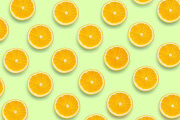 Colorful fruit pattern of fresh orange slices on colored background. Orange slices top view.