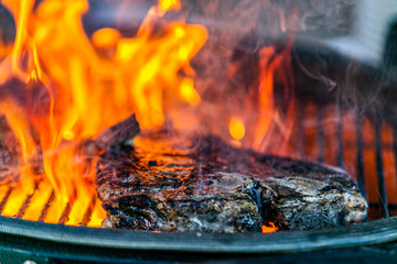Grilling steaks on flaming grill.Beef steaks on grill.Grilling steak on BBQ © Ivan