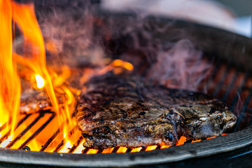 Grilling steaks on flaming grill.Beef steaks on grill.Grilling steak on BBQ