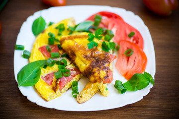 fried omelet from homemade organic eggs with tomatoes and green onions