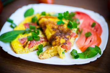 fried omelet from homemade organic eggs with tomatoes and green onions