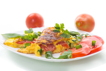 fried omelet from homemade organic eggs with tomatoes and green onions
