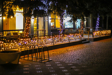 Fototapeta na wymiar Cafe with lots of lights. Winter evening. Nobody. Evening. Winter comfort. Winter holidays