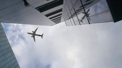 Airplane flying over skyscrapers and reflects in glass modern facades, Germany