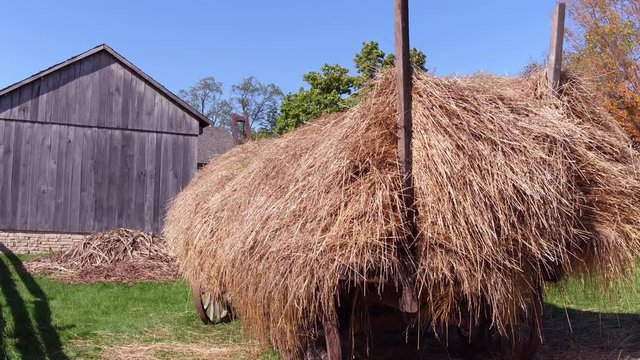 Wagon with straw on farm land establishing shot.