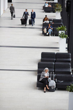 Directly Above View Of Modern Business People Sitting On Leather Sofas And Walking In Airport Area