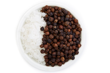 Bowl of black pepper with salt on white