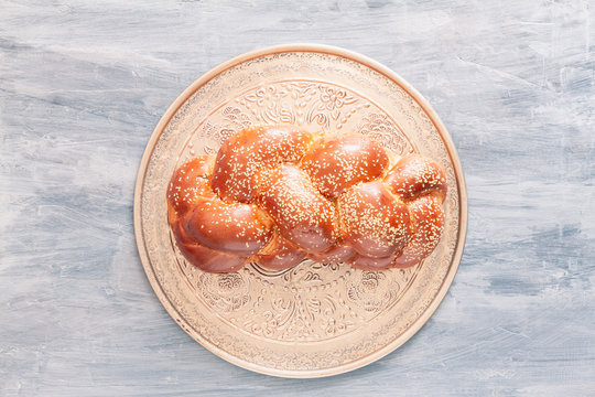 Shabbat or Sabbath kiddush ceremony composition with a traditional sweet fresh loaf of challah bread, vintage background with copy space. Overhead view, top view or above view comoisition..