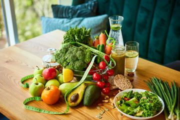 Diet weight loss breakfast concept with tape measure, organic fruits , vegetables, salad and fresh water. Healthy nutrition concept, Lifestyle and Eating