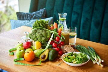 Diet weight loss breakfast concept with tape measure, organic fruits , vegetables, salad and fresh water. Healthy nutrition concept, Lifestyle and Eating