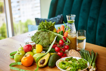 Diet weight loss breakfast concept with tape measure, organic fruits , vegetables, salad and fresh water. Healthy nutrition concept, Lifestyle and Eating