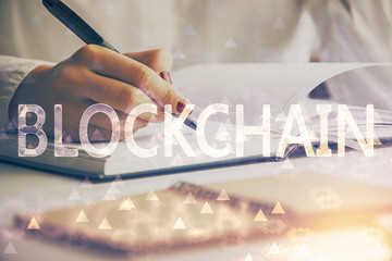 Cryptocurrency hologram over woman's hands writing background. Concept of blockchain. Double...
