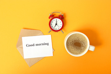 alarm clock and coffee on a colored background top view.