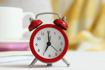 Alarm clock and cup of coffee in the room interior