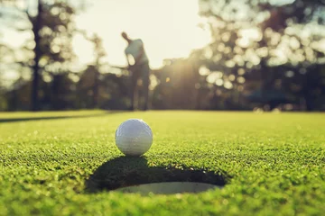 Foto auf Acrylglas golf player putting golf ball into hole © lovelyday12
