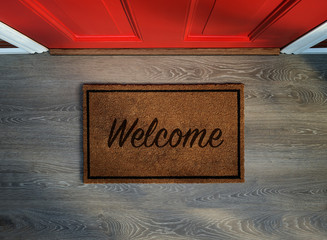 Overhead view of welcome mat outside inviting front door of house - obrazy, fototapety, plakaty
