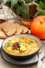 Homemade lentil soup with bread and parsley on wooden table
