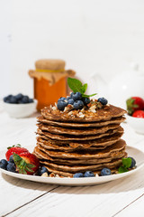 stack of homemade pancakes for breakfast on white table, vertical