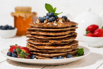 stack of homemade pancakes with fresh berries for breakfast, closeup