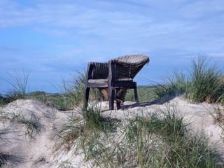 Fototapeta na wymiar Korbsessel auf Düne am Strand