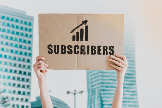 The word " Subscribers " and going up c drawn on a carton banner in men's hand. Human holds a cardboard with an inscription: Subscribers