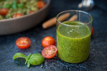 Green Basil pesto sauce on black concrete background
