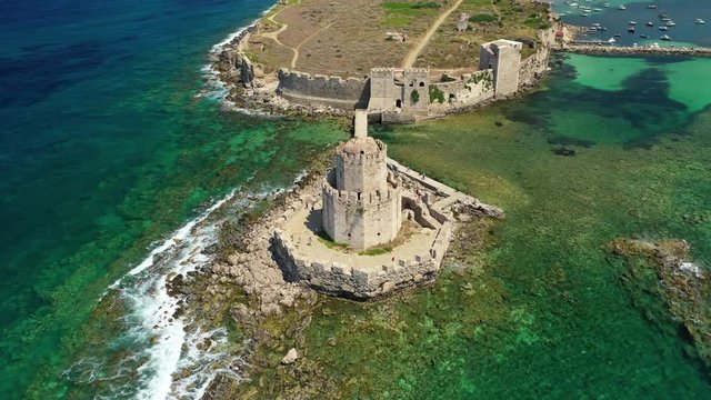 Aerial drone video of iconic Venetian tower of Bourtzi and medieval fortified castle in picturesque village of Methoni, Messinia, Peloponnese, Greece