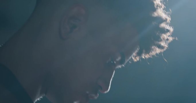 Cinematic slow motion close up shot of a professional young african man is practicing basketball work out in a gym. 